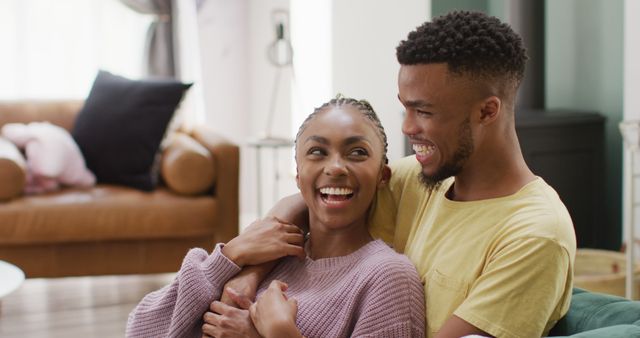 Happy african american couple talking and hugging on sofa - Download Free Stock Photos Pikwizard.com
