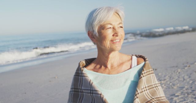 Happy senior caucasian woman smiling on beach. Senior lifestyle, realxation, nature, free time and vacation.