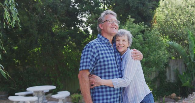 Portrait of happy senior caucasian couple embracing and smiling in garden. Senior lifestyle and domestic life.