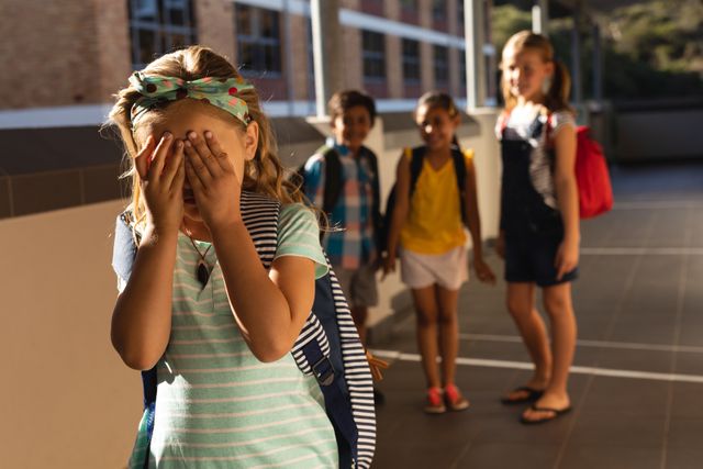 School friends bullying a crying girl in hallway of elementary school - Download Free Stock Photos Pikwizard.com