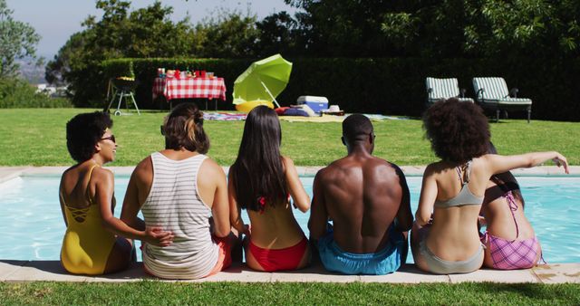 Diverse group of friends sitting in a row at a pool party. hanging out and relaxing outdoors in summer.