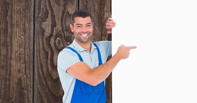 Happy male worker pointing at blank bill board - Download Free Stock Photos Pikwizard.com