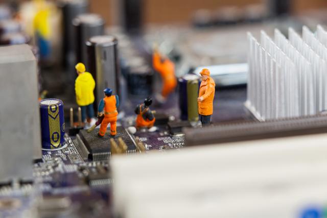 Miniature workers working on chip of motherboard - Download Free Stock Photos Pikwizard.com