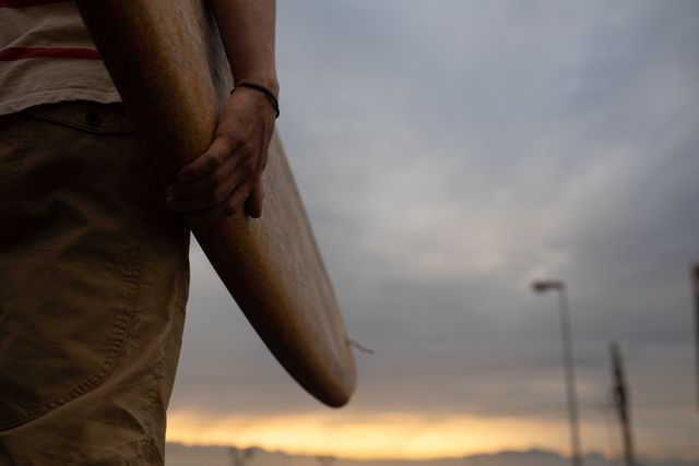 Low section of man holding a surf board - Download Free Stock Photos Pikwizard.com