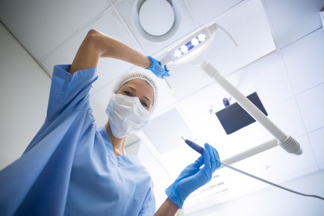 Dental assistant in surgical mask holding dental tools - Download Free Stock Photos Pikwizard.com