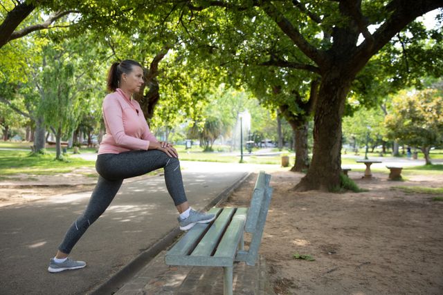 Senior female woman stretching her legs in the park - Download Free Stock Photos Pikwizard.com