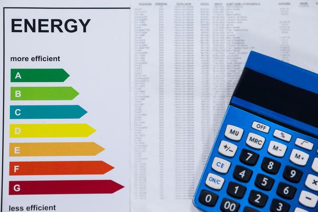 Energy efficiency rating and calculator on a wooden table - Download Free Stock Photos Pikwizard.com