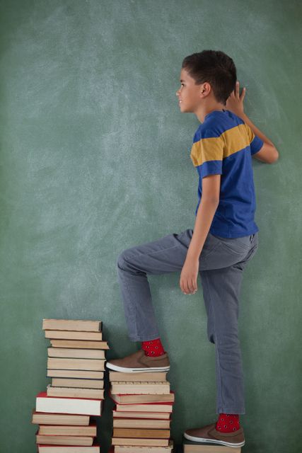 Schoolboy climbing steps of books stack - Download Free Stock Photos Pikwizard.com