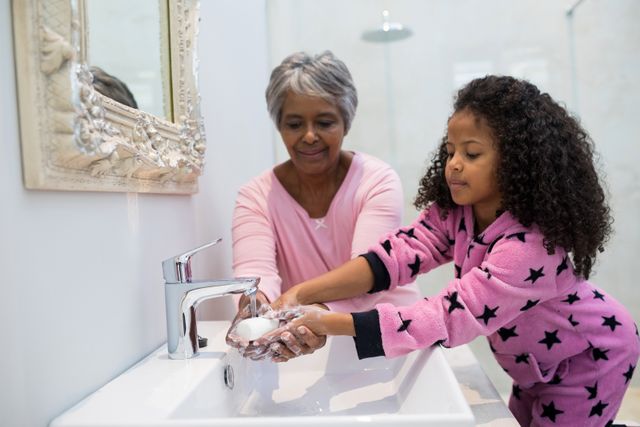 Grandmother and granddaughter washing hands with soap in bathroom sink - Download Free Stock Photos Pikwizard.com