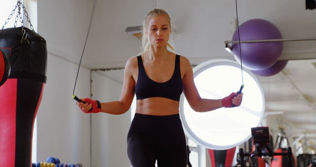 A dedicated young woman exercises with a jump rope in a gym, highlighting her fitness zeal. - Download Free Stock Photos Pikwizard.com