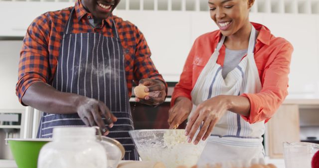 Image of happy african american couple baking together in kitchen. Love, relationship and spending quality time together concept.
