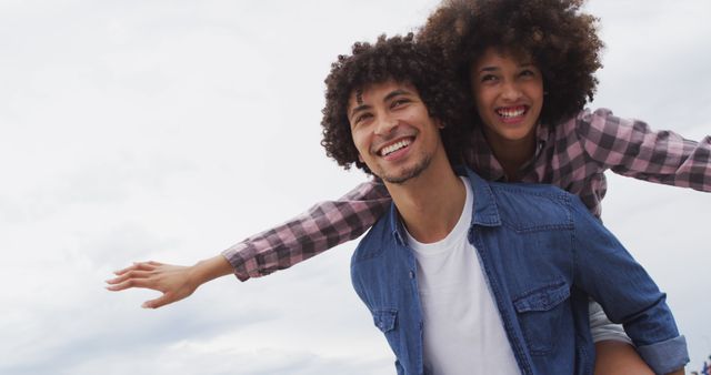 Lovely gay couple on piggyback ride at the beach. Stock Photo