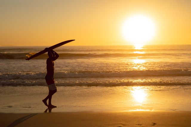 Man walking with surfboard on his head at beach - Download Free Stock Photos Pikwizard.com