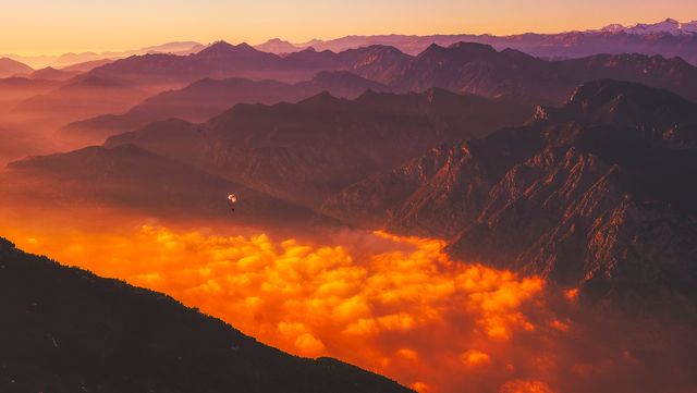 a mountain range with orange clouds - Download Free Stock Photos Pikwizard.com