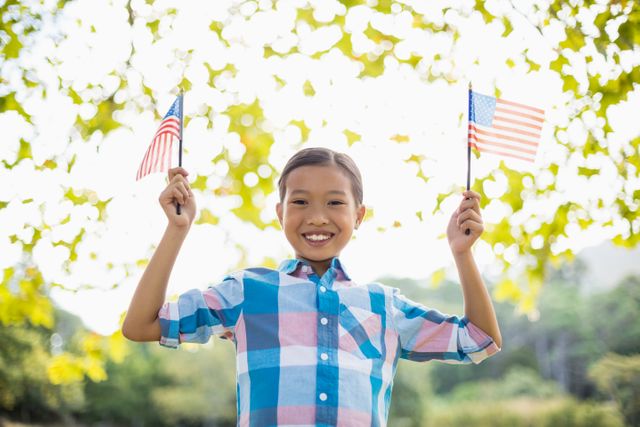 Portrait of girl holding an American flag in park