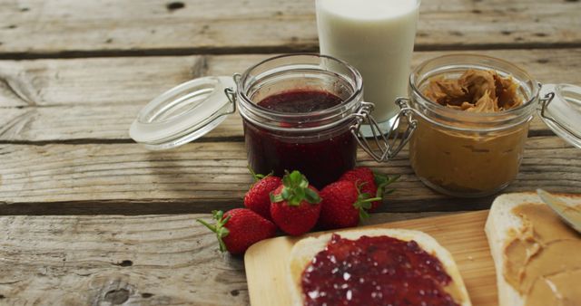 Peanut butter and jelly sandwich on wooden tray with milk and strawberries on wooden surface. food and nutrition concept