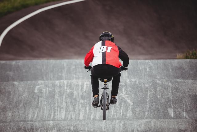 Rear view of cyclist riding BMX bike in skatepark