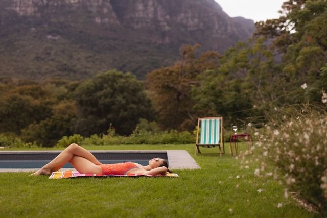 Woman in swimwear relaxing near poolside in the backyard - Download Free Stock Photos Pikwizard.com