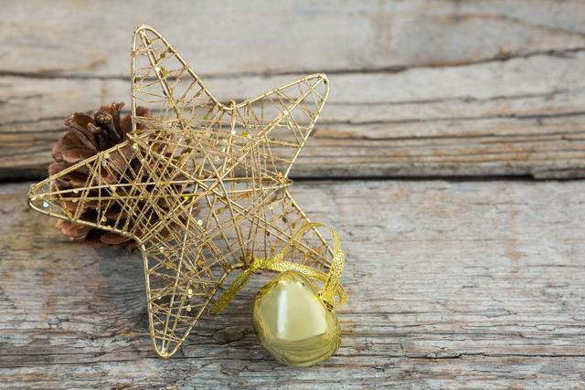 Christmas bell, pine cone and star on wooden plank - Download Free Stock Photos Pikwizard.com