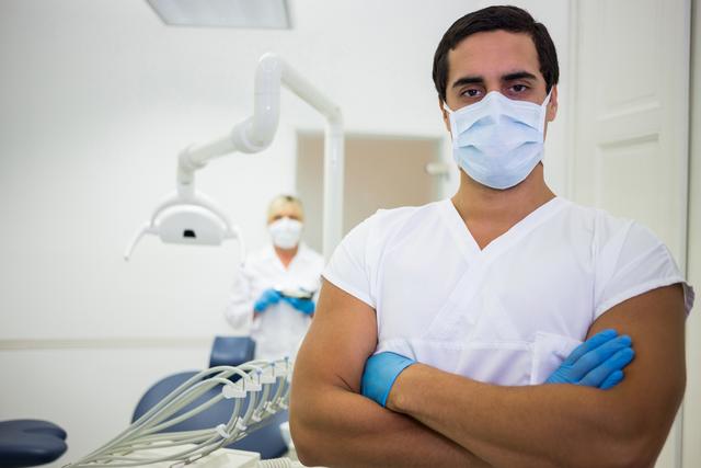 Portrait of male dentist standing with arms crossed - Download Free Stock Photos Pikwizard.com