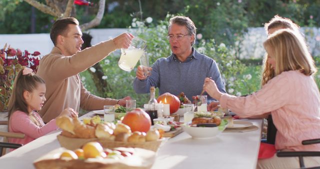 Image of happy caucasian parents, daughter and grandparents serving food and drinks at outdoor table - Download Free Stock Photos Pikwizard.com