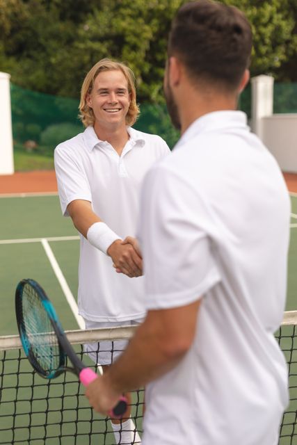 Two male tennis players shaking hands in tennis court - Download Free Stock Photos Pikwizard.com