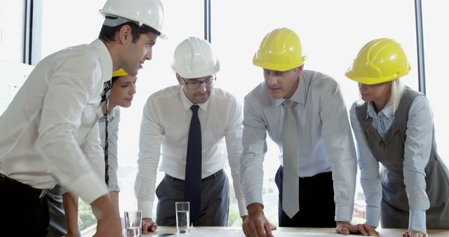 A diverse team of construction and engineering professionals collaboratively discuss plans. - Download Free Stock Photos Pikwizard.com