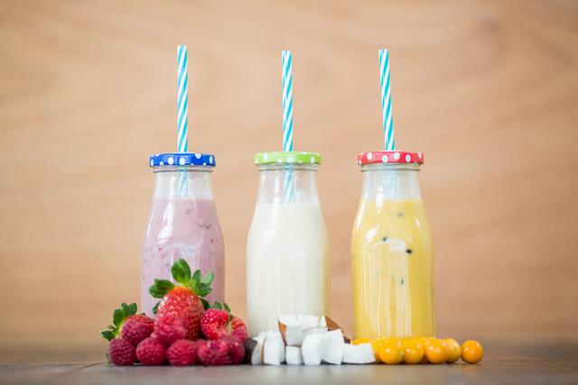Three bottles with smoothies and fresh chopped fruits - Download Free Stock Photos Pikwizard.com