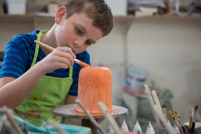 Boy painting a bowl in pottery shop - Download Free Stock Photos Pikwizard.com