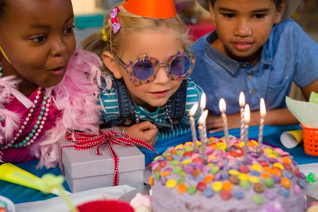 Close up of children looking at birthday cake - Download Free Stock Photos Pikwizard.com