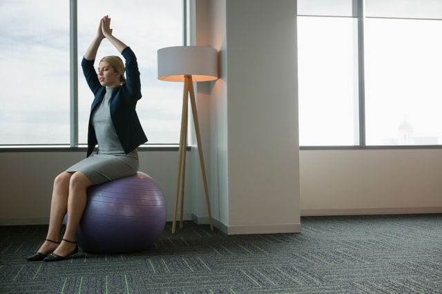 Executive meditating on fitness ball - Download Free Stock Photos Pikwizard.com