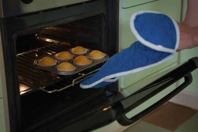 Woman putting muffins in oven - Download Free Stock Photos Pikwizard.com