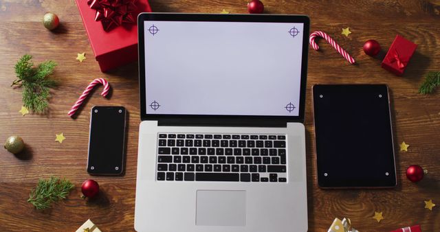 Image of christmas decorations with laptop and copy space on wooden table. christmas, communication, tradition and celebration concept.