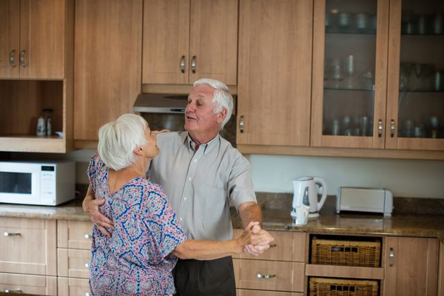 Senior couple dancing together in kitchen - Download Free Stock Photos Pikwizard.com