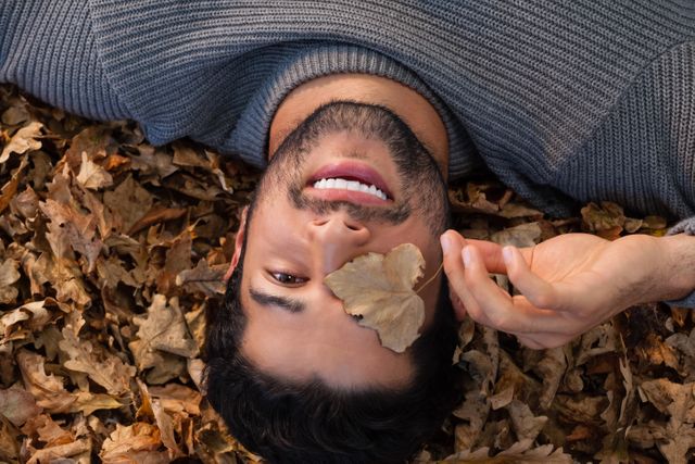 Portrait of man lying on autumn leaves