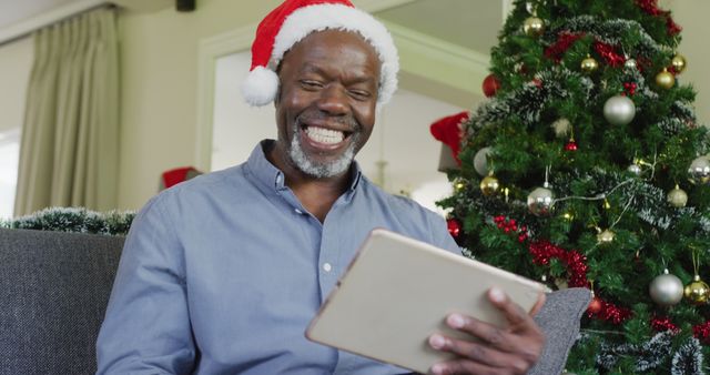 Happy senior african american man using tablet at christmas - Download Free Stock Photos Pikwizard.com