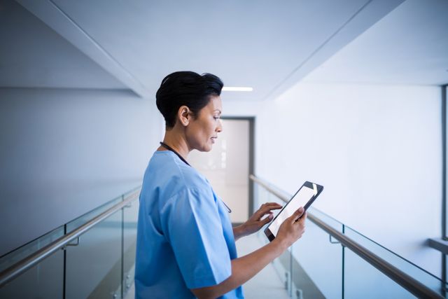 Female nurse using digital tablet in corridor - Download Free Stock Photos Pikwizard.com