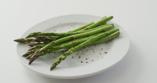 Image of fresh asparagus stalks on white plate over white background - Download Free Stock Photos Pikwizard.com