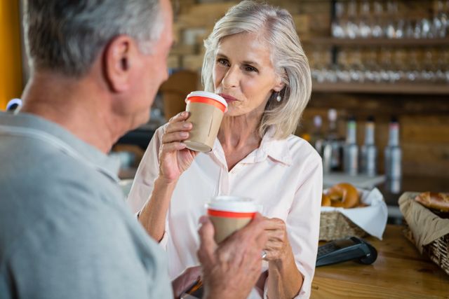 Senior couple interacting with each other while having coffee - Download Free Stock Photos Pikwizard.com