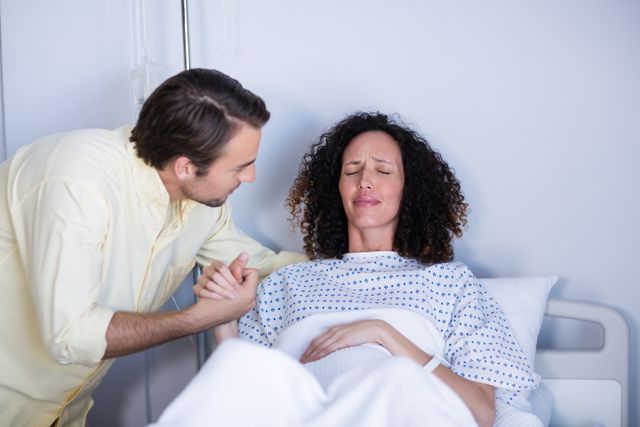 Man comforting pregnant woman during labor in ward - Download Free Stock Photos Pikwizard.com