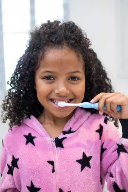 Smiling girl brushing her teeth in bathroom - Download Free Stock Photos Pikwizard.com