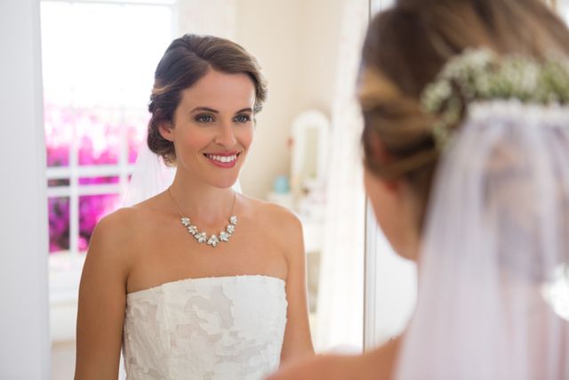 Beautiful bride looking into mirror in room - Download Free Stock Photos Pikwizard.com