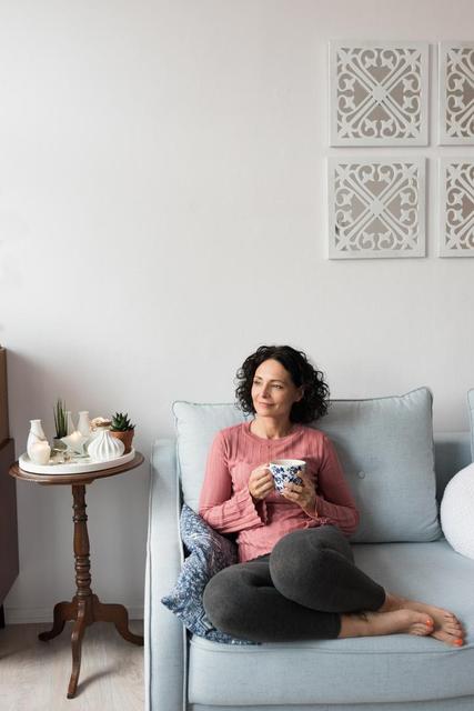 Beautiful woman holding a coffee cup at home