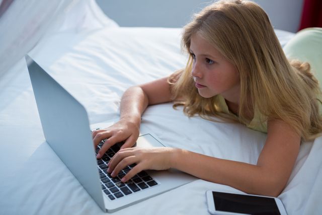 Girl using laptop on bed - Download Free Stock Photos Pikwizard.com