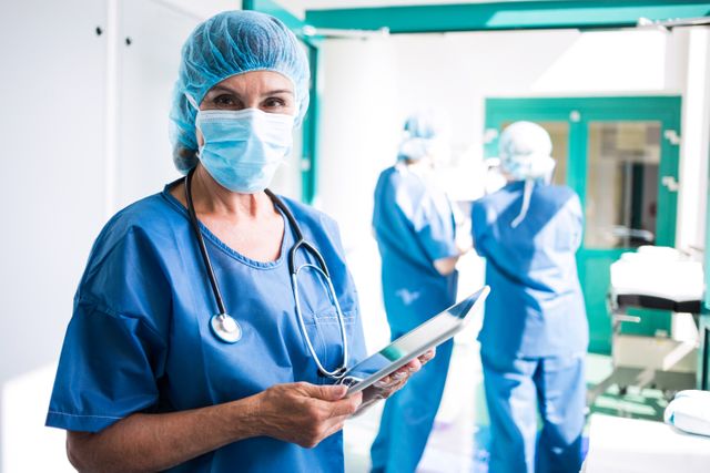 Surgeon using digital tablet in hospital corridor