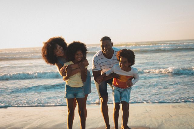 Portrait of happy african american parents and children embracing on beach at sunset - Download Free Stock Photos Pikwizard.com