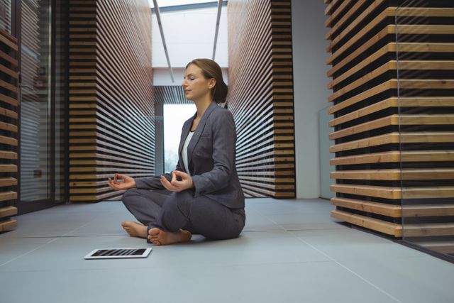 Businesswoman performing yoga in the corridor - Download Free Stock Photos Pikwizard.com