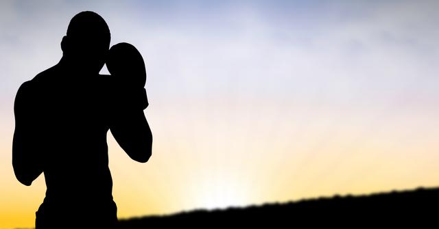Digital composite of Silhouette man wearing boxing glove during sunset