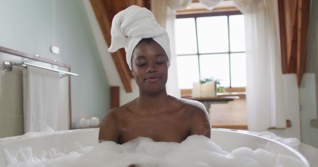 Woman taking bubble bath in bathroom at home from Pikwizard