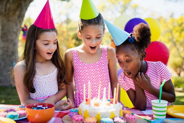 Portrait of cute girls preparing to blow on candle during a birthday party - Download Free Stock Photos Pikwizard.com